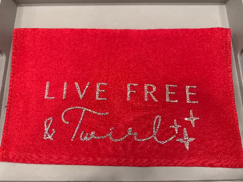 Red towel with 'Live Free' text on a metallic surface